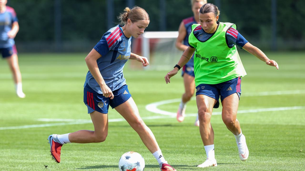 Ella Rauscha und Arianna Caruso vom FC Bayern München spielen um den Ball, im Hintergrund verschwommen zwei weitere Spielerinnen.