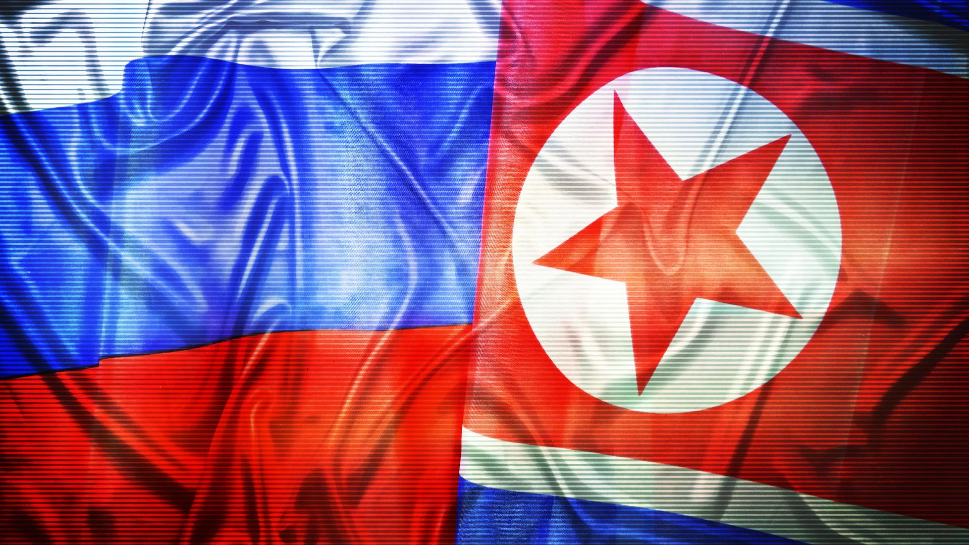 Die russische Flagge hat weiß-blau-rote Querstreifen. Die nordkoreanische rot-weiß-blaue, wobei der obere rote dicker ist. Darin ist ein weißer Kreis mit einem roten Strern. Das Bild wirkt durch dünne waagrechte graue Streifen sehr grobkörnig.