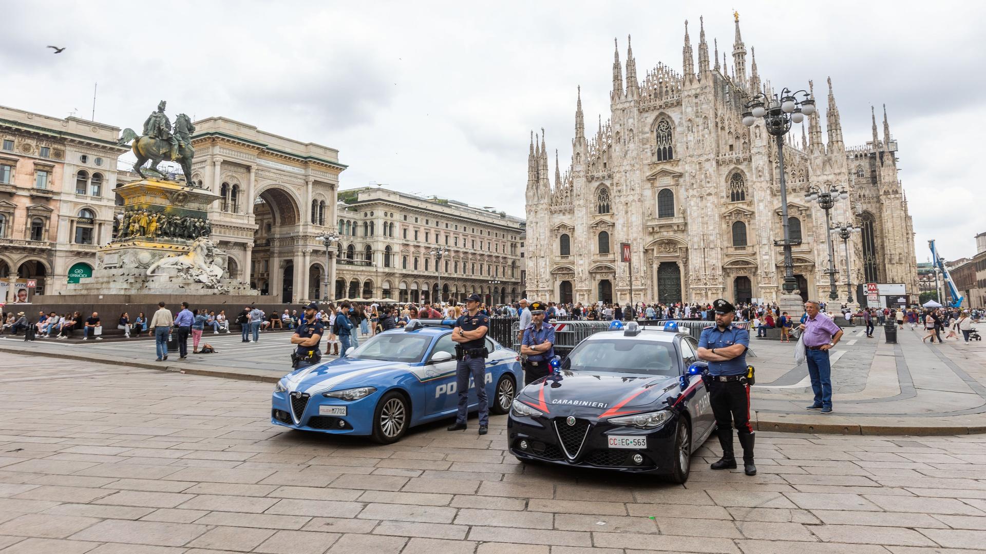 Mailand: Polizisten stehen neben ihren Einsatzfahrzeugen neben Absperrungen auf dem Domplatzes Piazza del Duomo in Mailand.