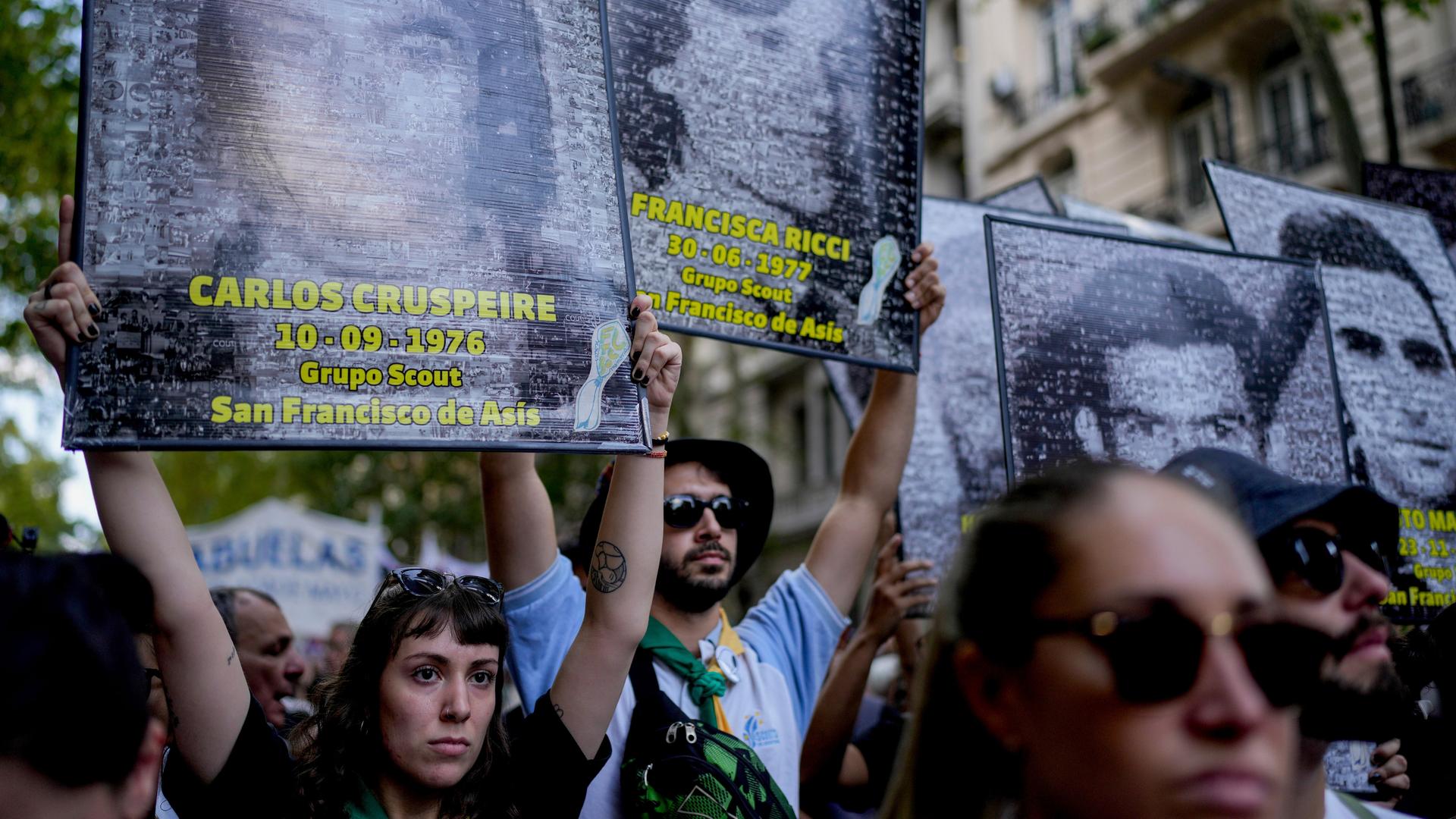 Demonstranten halten Transparente mit Fotos hoch, auf denen Opfer der Militärdiktatur in Argentinien abgebildet sind.