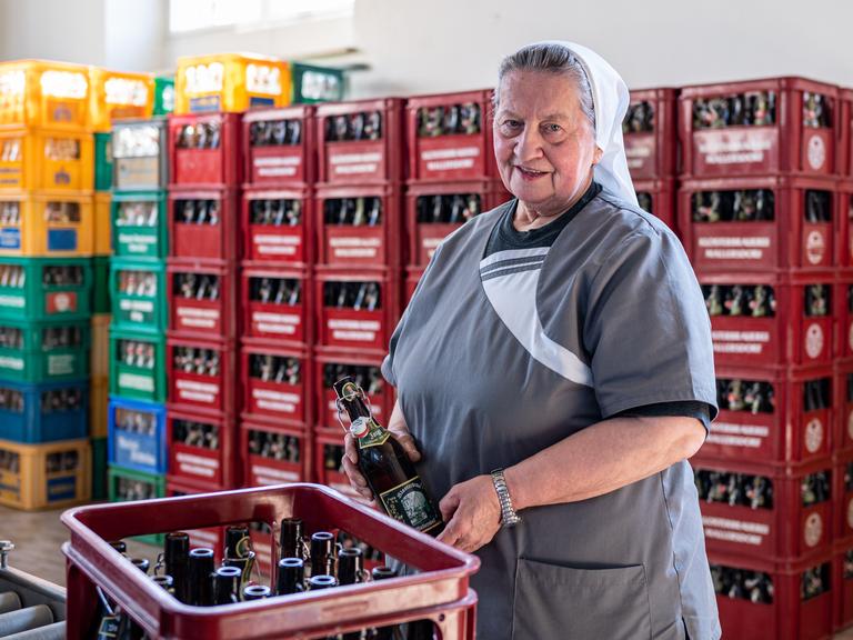Schwester Doris, Braumeisterin und Ordensschwester im Kloster Mallersdorf, steht in der Klosterbrauerei vor Bierkästen. 