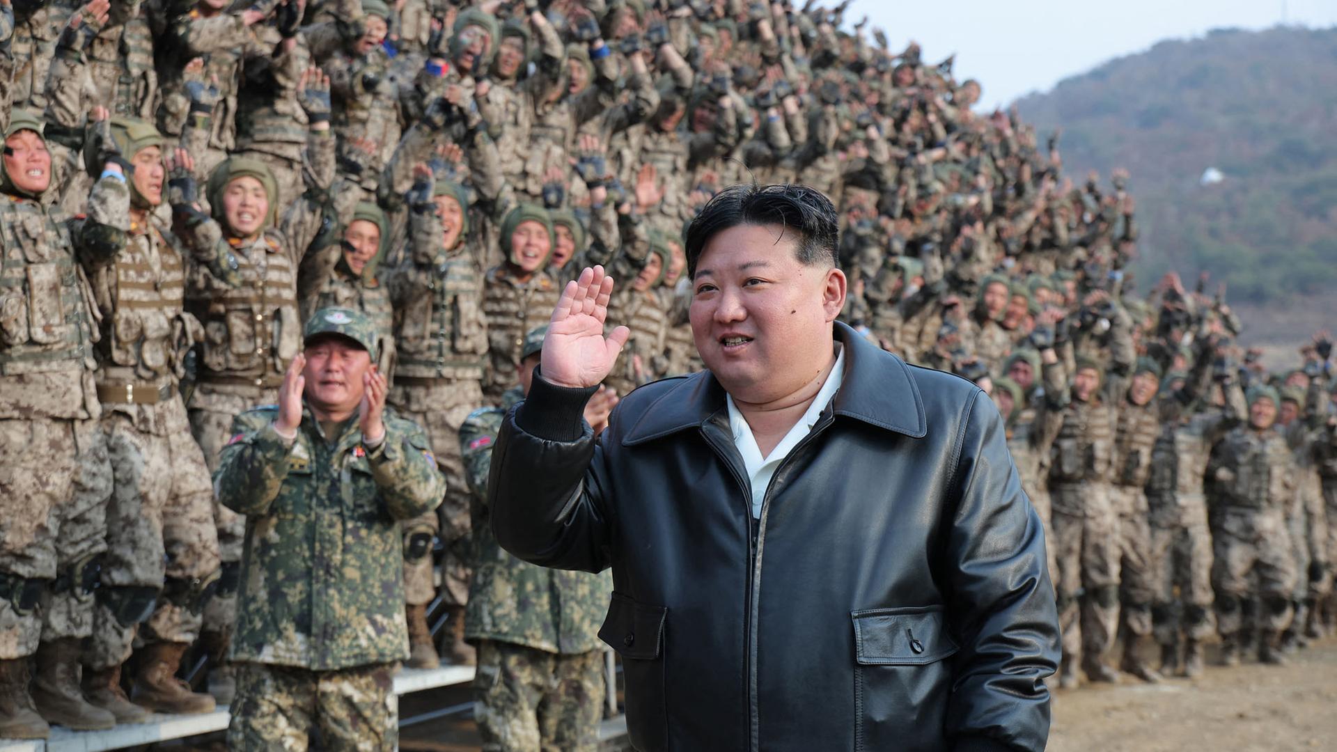 Kim Jong Un geht grüßend an Soldaten vorbei. Die Soldaten winken und klatschen.