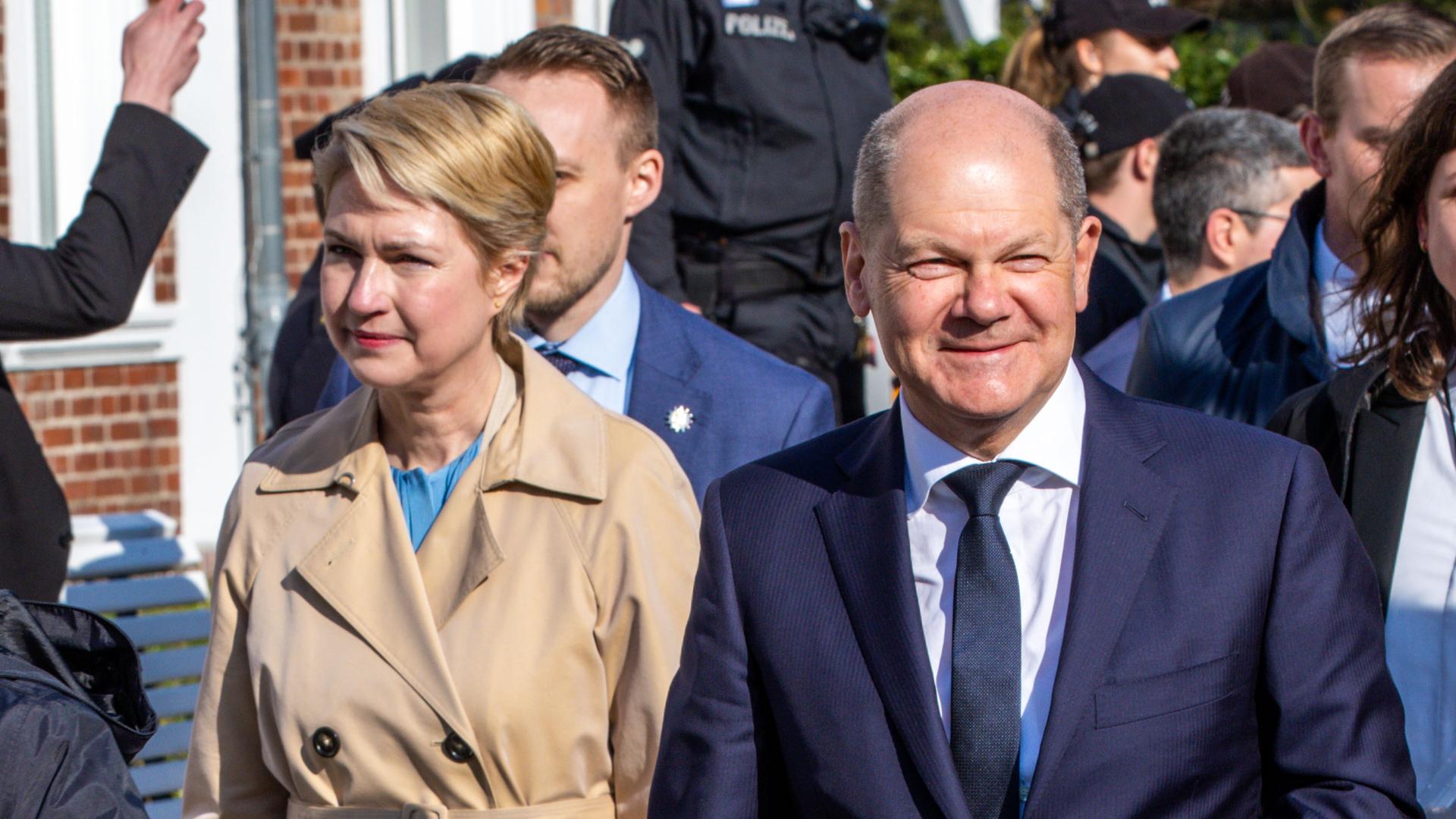 Zwei Personen laufen abgeschirmt von einer Personenschützerin. Zwei Personen laufen abgeschirmt von einer Personenschützerin.
