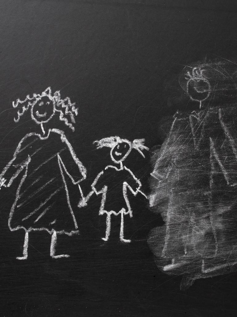 Kreidezeichnung einer Familie an einer Tafel, bei der der Vater halb weggewischt wurde.