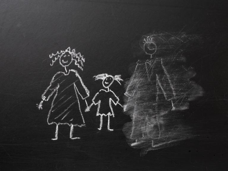 Kreidezeichnung einer Familie an einer Tafel, bei der der Vater halb weggewischt wurde.