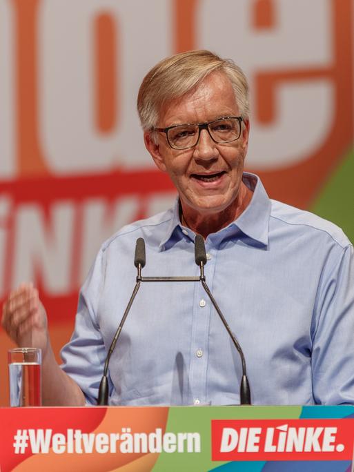 Ein Mann steht auf einer Bühne und hält eine Rede. Er trägt ein hellblaues Hemd. Es ist der Linke-Politker Dietmar Bartsch.
