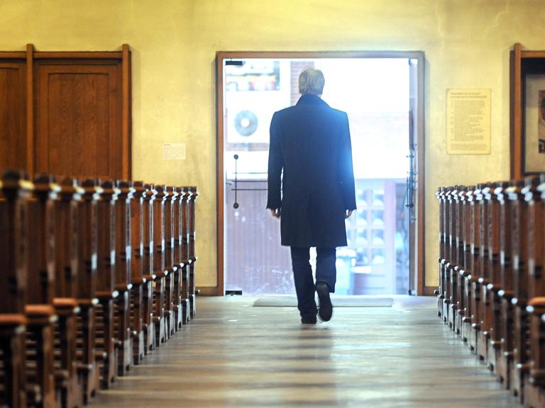 Symbolbild: Ein Mann verlässt eine Kirche - dem Betrachter wendet er den Rücken zu