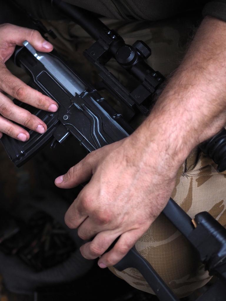 Die Hände eines Soldaten am Gewehr. Close-Up