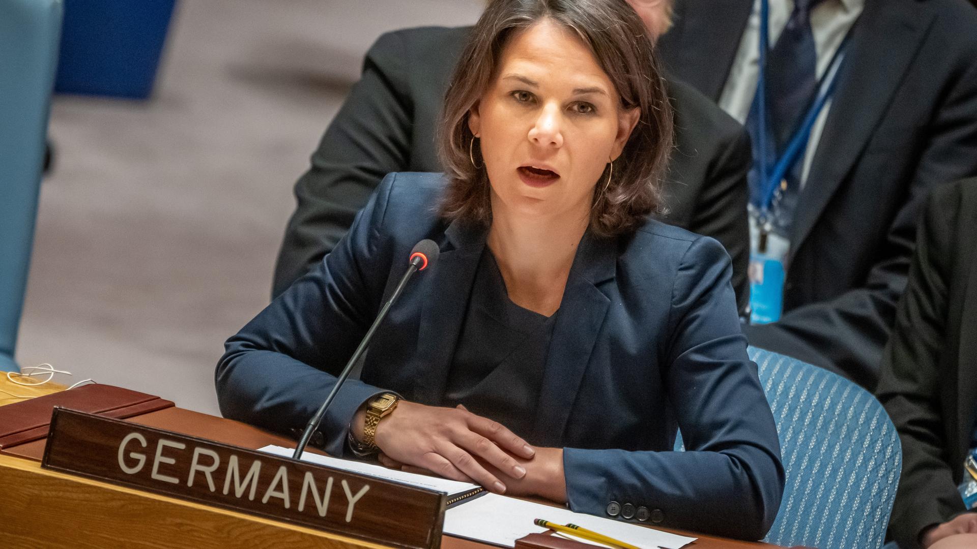 Annalena Baerbock sitzt an einem Tisch im Sicherheitsrat und spricht in ein Mikrofon. Ein Schild auf dem Tisch zeigt an, dass sie Deutschland vertritt. Hinter ihr sitzen noch einige andere Personen.