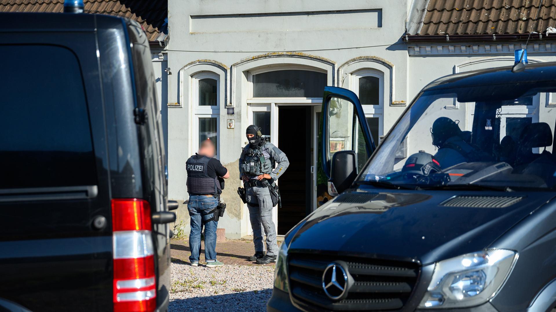 Einsatzkräfte der Bundespolizei stehen vor einem Wohnhaus. Der Bundespolizei ist ein Schlag gegen die Schleuserkriminalität gelungen.