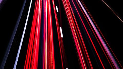 Langzeitbelichtung auf der Autobahn bei Nacht erzeugt rote und weiße Streifen auf schwarzem Asphalt Langzeitbelichtung auf der Autobahn bei Nacht erzeugt rote und weiße Streifen auf schwarzem Asphalt