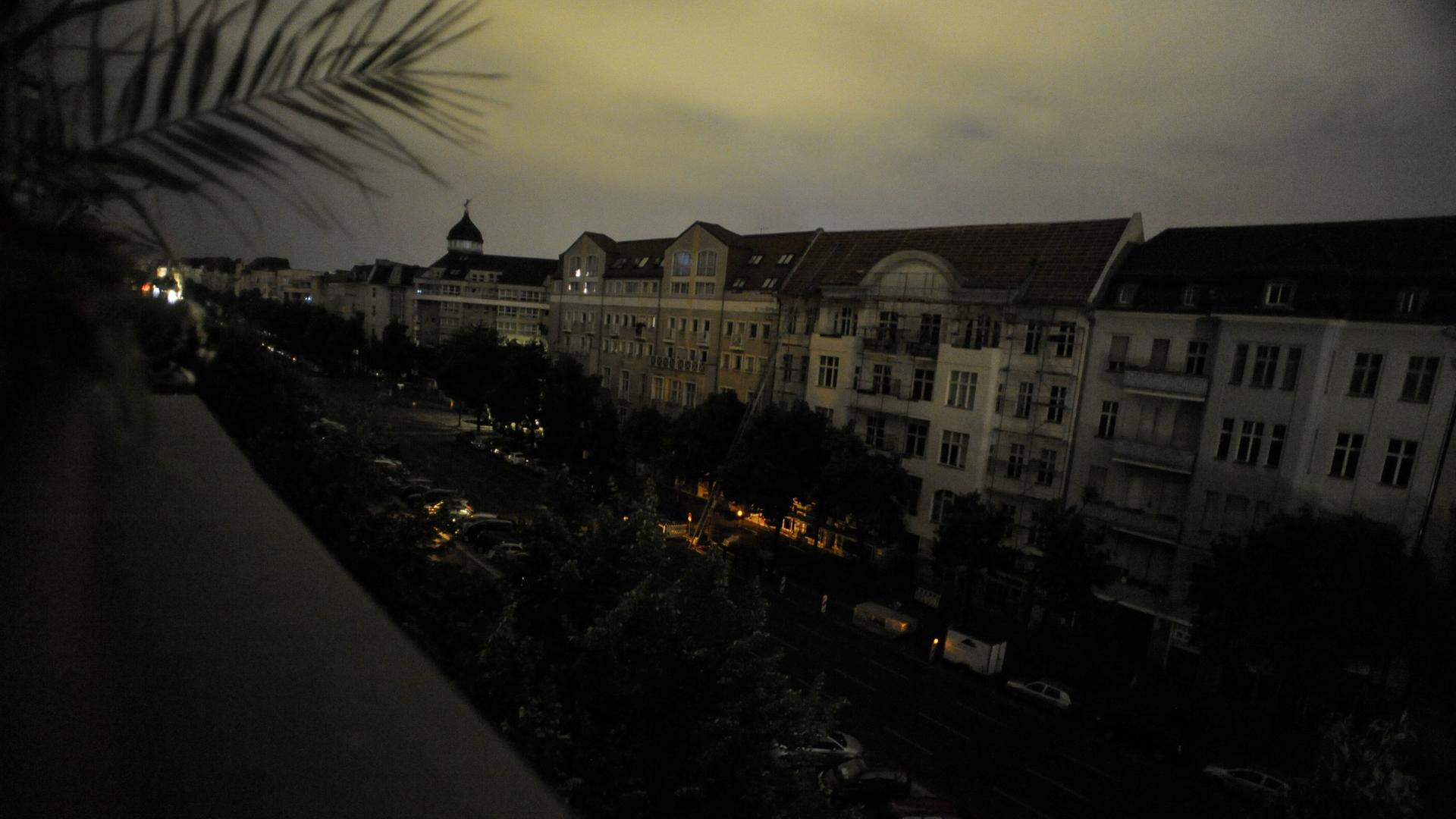 Blick von einem Balkon aus auf den Berliner Kaiserdamm mit komplett dunklen Fenstern in der Nacht.