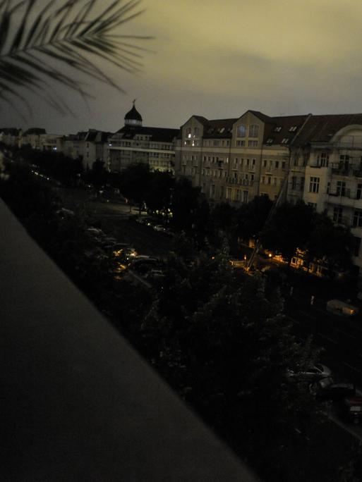 Blick von einem Balkon aus auf den Berliner Kaiserdamm mit komplett dunklen Fenstern in der Nacht.