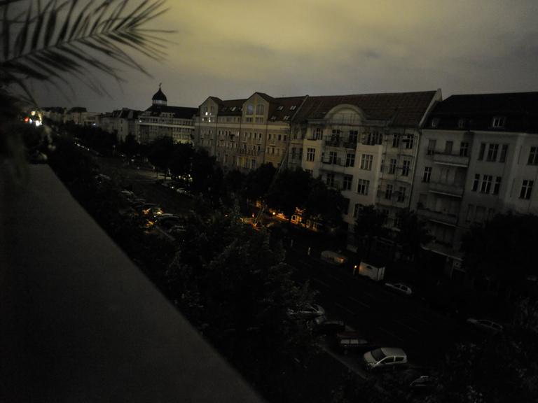 Blick von einem Balkon aus auf den Berliner Kaiserdamm mit komplett dunklen Fenstern in der Nacht.