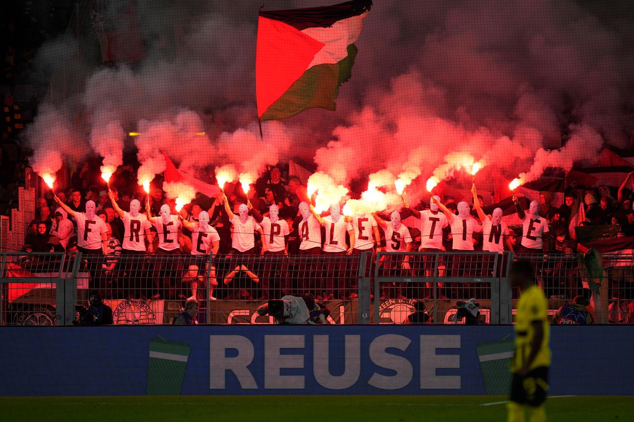 Celtic-Fans zünden im Dortmunder Gästeblock Pyrotechnik und zeigen Free Palestine Shirts und Fahnen.