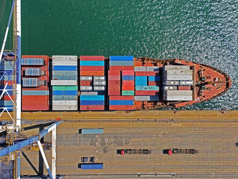 Blick von oben auf ein Containerschiff im Hafen