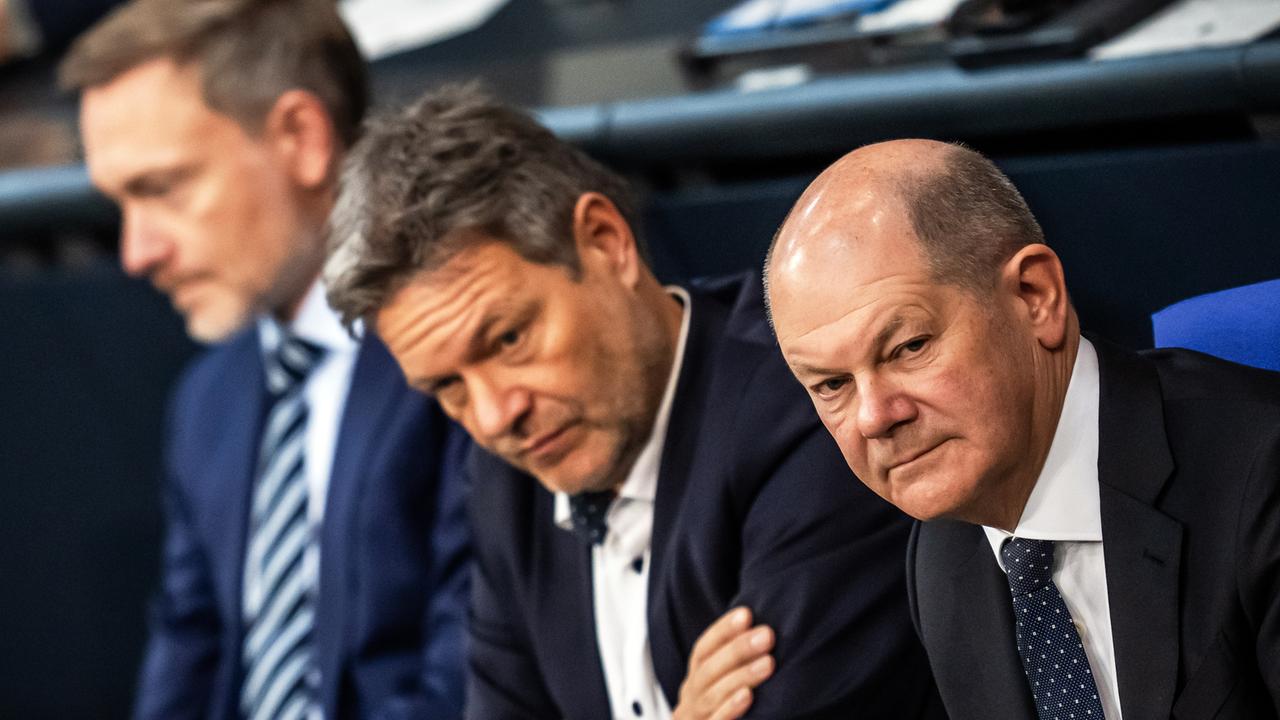 Bundeskanzler Olaf Scholz (SPD, r), verfolgt neben Robert Habeck (Bündnis 90/Die Grünen, M), Bundesminister für Wirtschaft und Klimaschutz, und Christian Lindner (FDP), Bundesminister der Finanzen, die Debatte nach einer Regierungserklärung zur Haushaltslage im Bundestag.