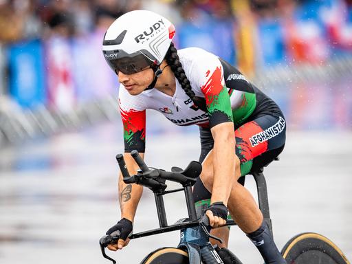 Die afghanische Radsportlerin Hashimi Yulduz fährt bei den Olympischen Spielen in Paris 2024 durch den Regen