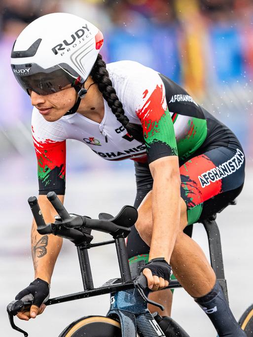 Die afghanische Radsportlerin Hashimi Yulduz fährt bei den Olympischen Spielen in Paris 2024 durch den Regen