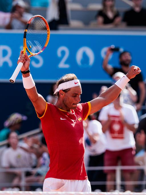 Rafael Nadal steht auf einem Tennisplatz und jubelt.