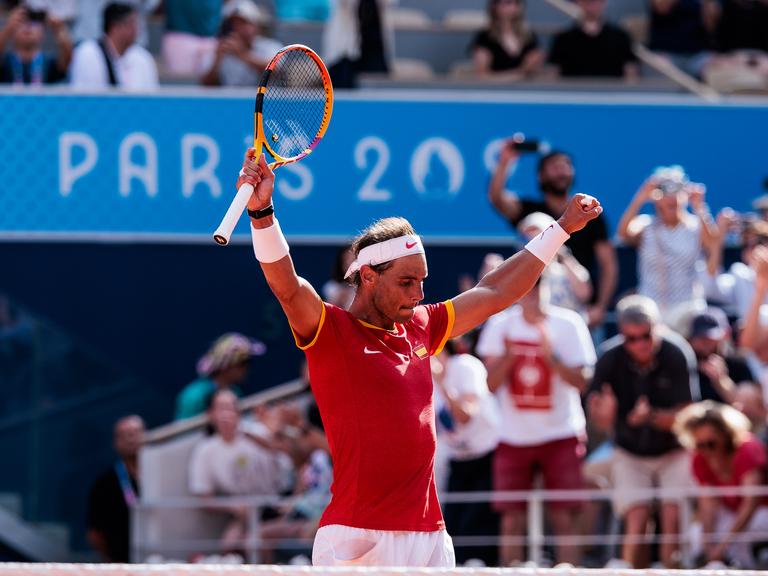 Rafael Nadal steht auf einem Tennisplatz und jubelt.