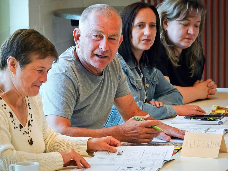 Drei Frauen und ein Mann in einem Deutschkurs für ukrainische Geflüchtete bei der evangelischen Flüchtlingshilfe in Gladbeck in Nordrhein-Westfalen.