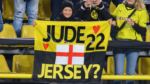 Ein junger Dortmund-Fan bittet Jude Bellinghammit einem Plakat um sein Trikot das ihm Bellinghorm (vorne) gibt. 