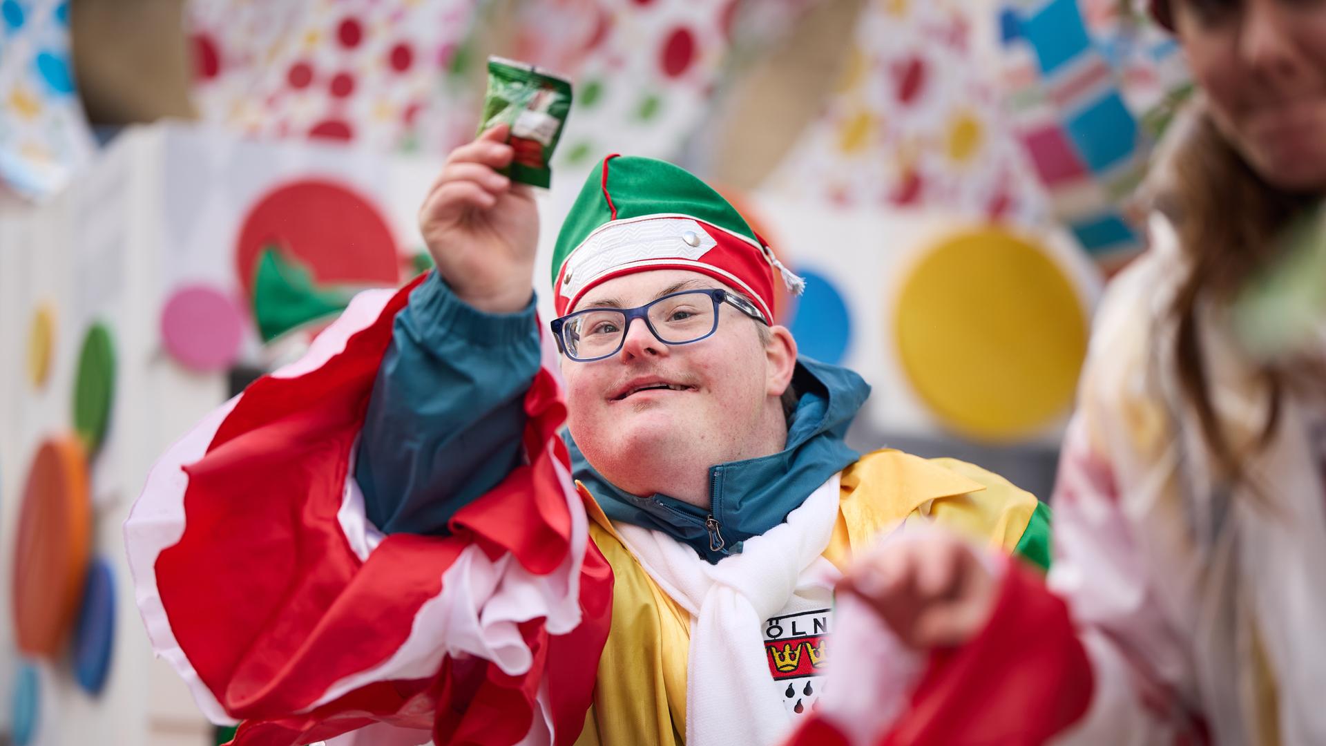 Ein kostümierter Mann hat Kamellen gefangen.