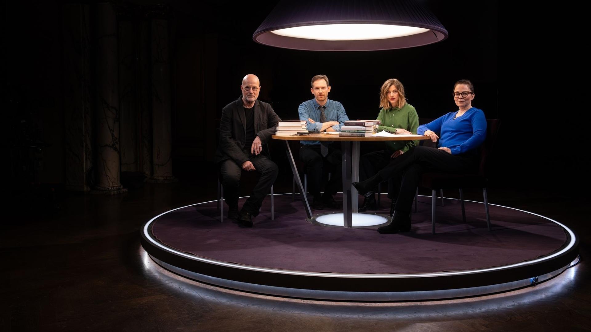 Christian Berkel, Xaver von Cranach, Marlene Knobloch und Thea Dorn sitzen an einem Tisch im Fernsehstudio und schauen in die Kamera.