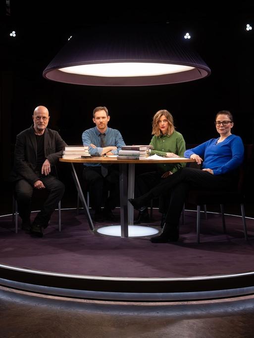 Christian Berkel, Xaver von Cranach, Marlene Knobloch und Thea Dorn sitzen an einem Tisch im Fernsehstudio und schauen in die Kamera.