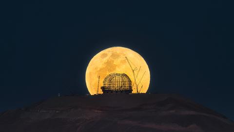 Der Aufgang eines gelben Vollmonds direkt hinter der Baustelle des Extremely Large Telecope der Europäischen Südsternwarte in Chile. 