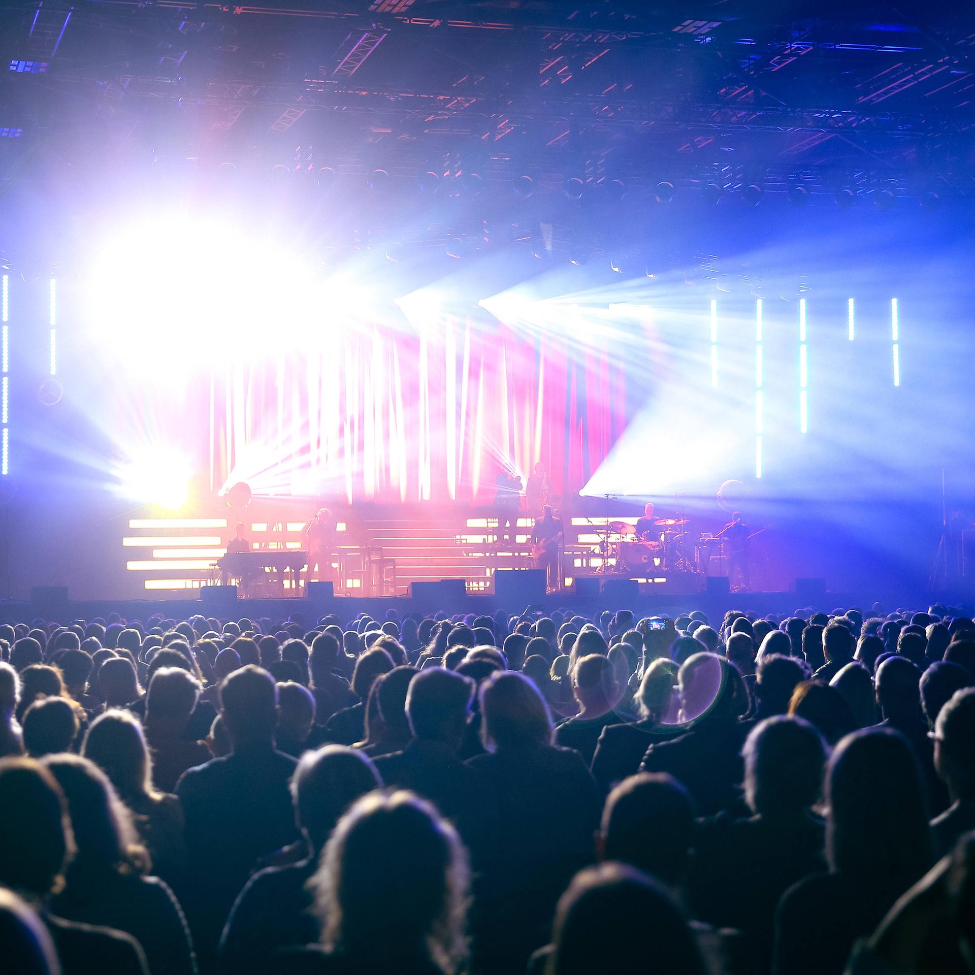 In der gut gefüllte Mitsubishi Electric Halle während eines Sasha-Konzertes strahlt das Licht von der Bühne über das Publikum