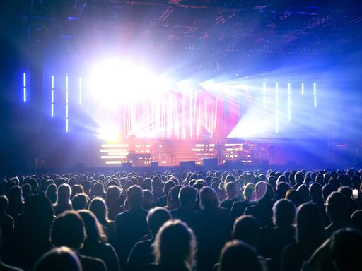 In der gut gefüllte Mitsubishi Electric Halle während eines Sasha-Konzertes strahlt das Licht von der Bühne über das Publikum