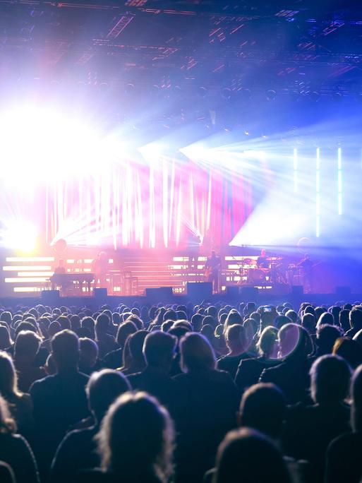 In der gut gefüllte Mitsubishi Electric Halle während eines Sasha-Konzertes strahlt das Licht von der Bühne über das Publikum