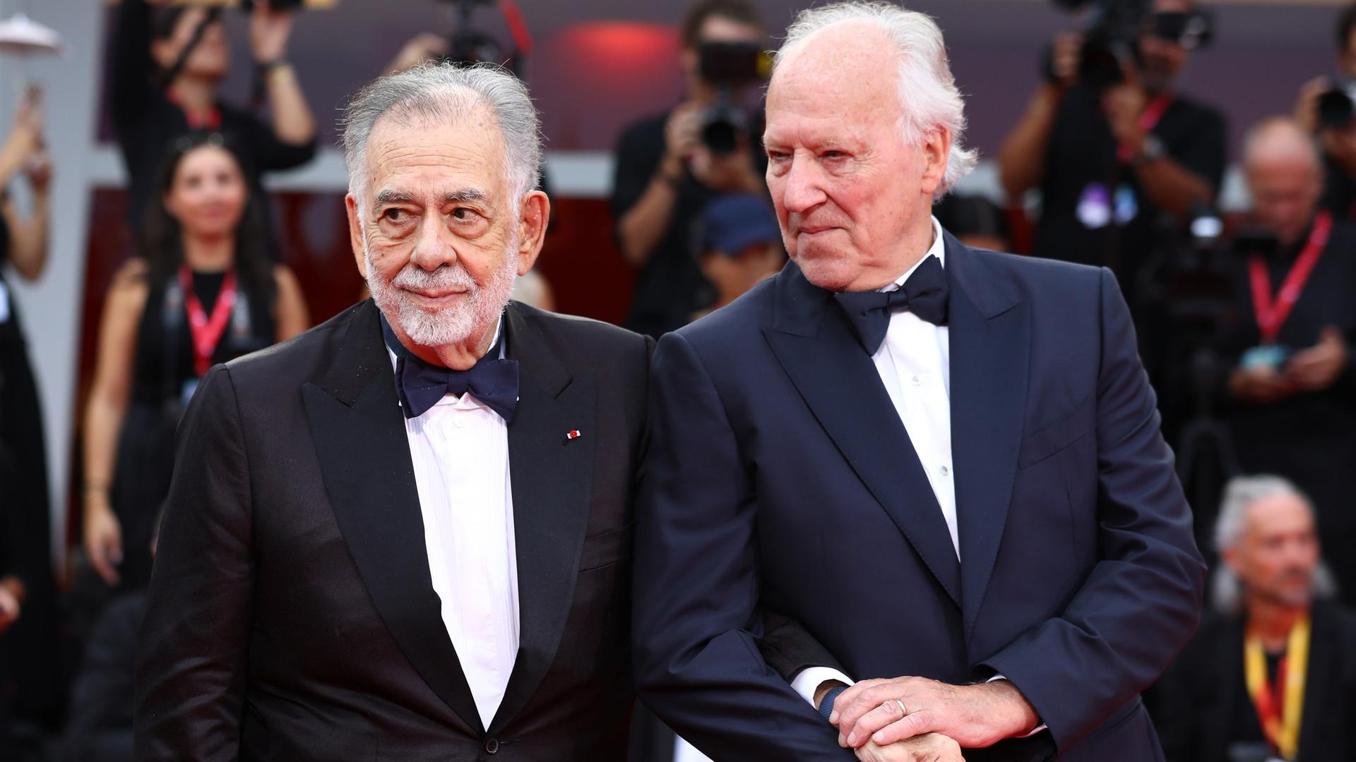 Francis Ford Coppola (l) und Werner Herzog kommen zur Eröffnungszeremonie und der Premiere des Films "La Grazia" während der 82. Ausgabe der Filmfestspiele von Venedig. Sie halten sich an den Händen. Francis Ford Coppola (l) und Werner Herzog kommen zur Eröffnungszeremonie und der Premiere des Films "La Grazia" während der 82. Ausgabe der Filmfestspiele von Venedig. Sie halten sich an den Händen.