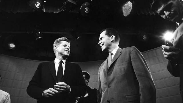 Historisches Schwarzweißfoto von John F. Kennedy und Richard Nixon, die im TV-Studio nebeneinander stehen.