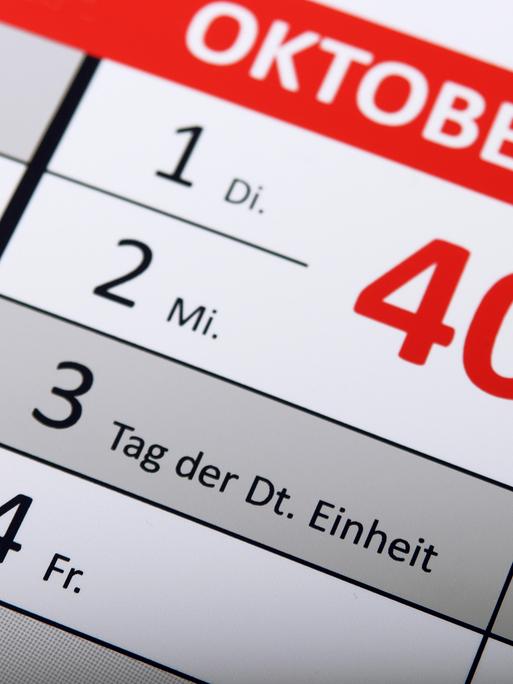 Detail eines Kalenders, auf dem der Tag der Deutschen Einheit als Feiertag hervorgehoben ist.