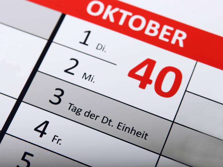 Detail eines Kalenders, auf dem der Tag der Deutschen Einheit als Feiertag hervorgehoben ist.