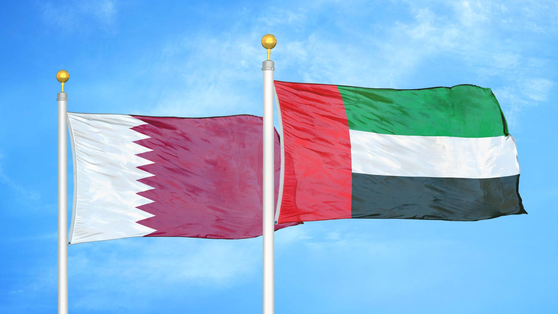 Die Landesfahnen der Arabischen Emirate und Katars wehen im Wind. Die Landesfahnen der Arabischen Emirate und Katars wehen im Wind.