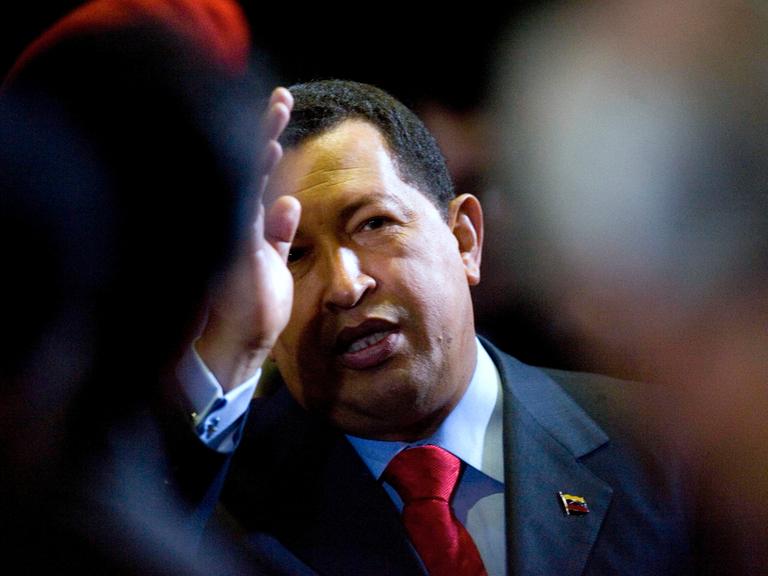 Der ehemalige, venezuelanische  President  Hugo  Chavez  (1954-2013) gestikuliert mit einer Hand vor seinem Gesicht.