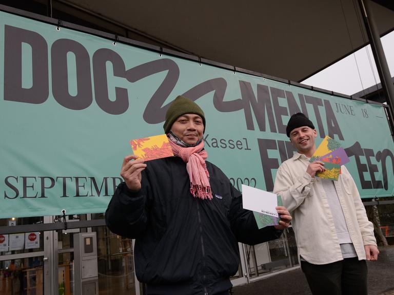 Reza Afisina (links) vom Kuratorenkollektiv Ruangrupa und Leon Schniewind, Inhouse Desinger bei der documenta, stehen mit Grußkarten bei der Vorstellung des neuen Logo der documenta fifteen.
