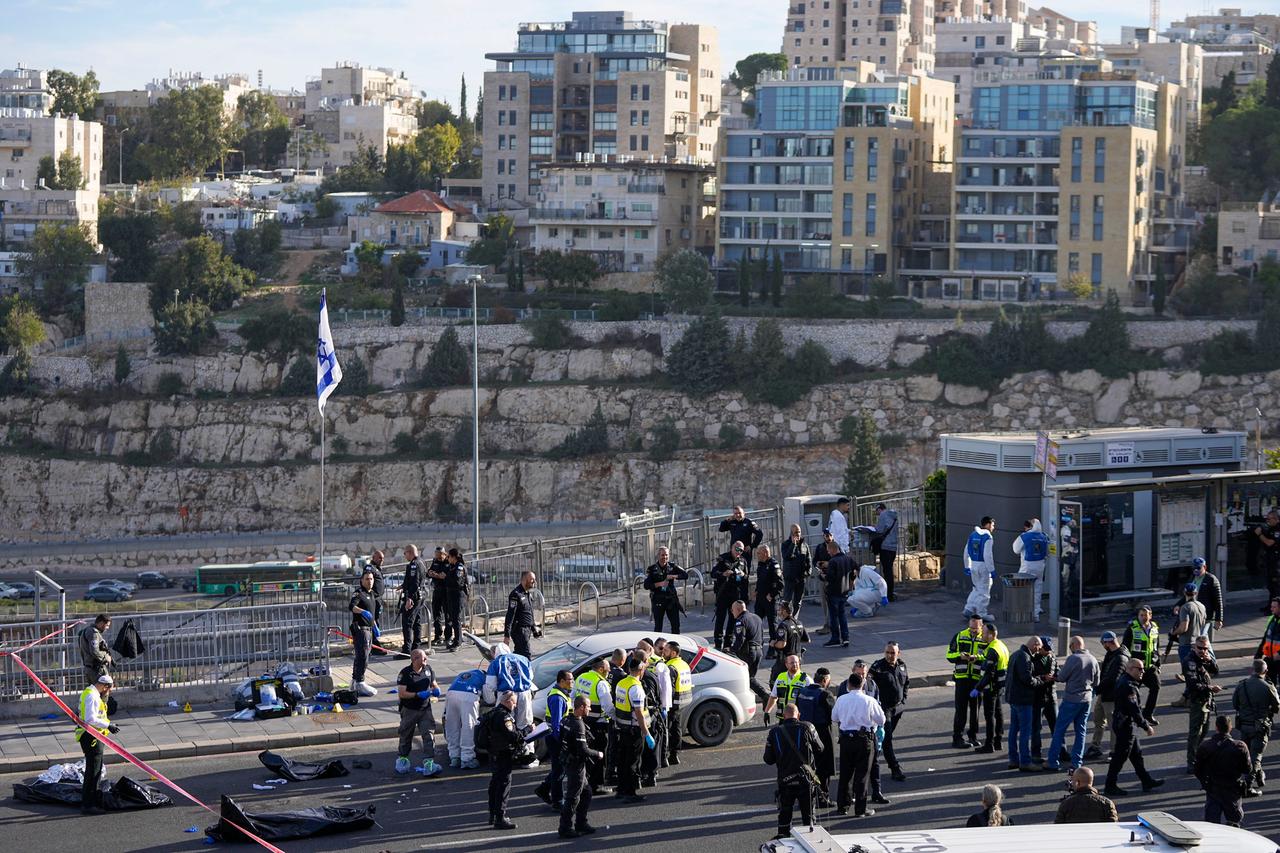 Israelische Polizisten stehen rund um die Bushaltestelle, an der eine Frau durch ein Attentat ums Leben kam.