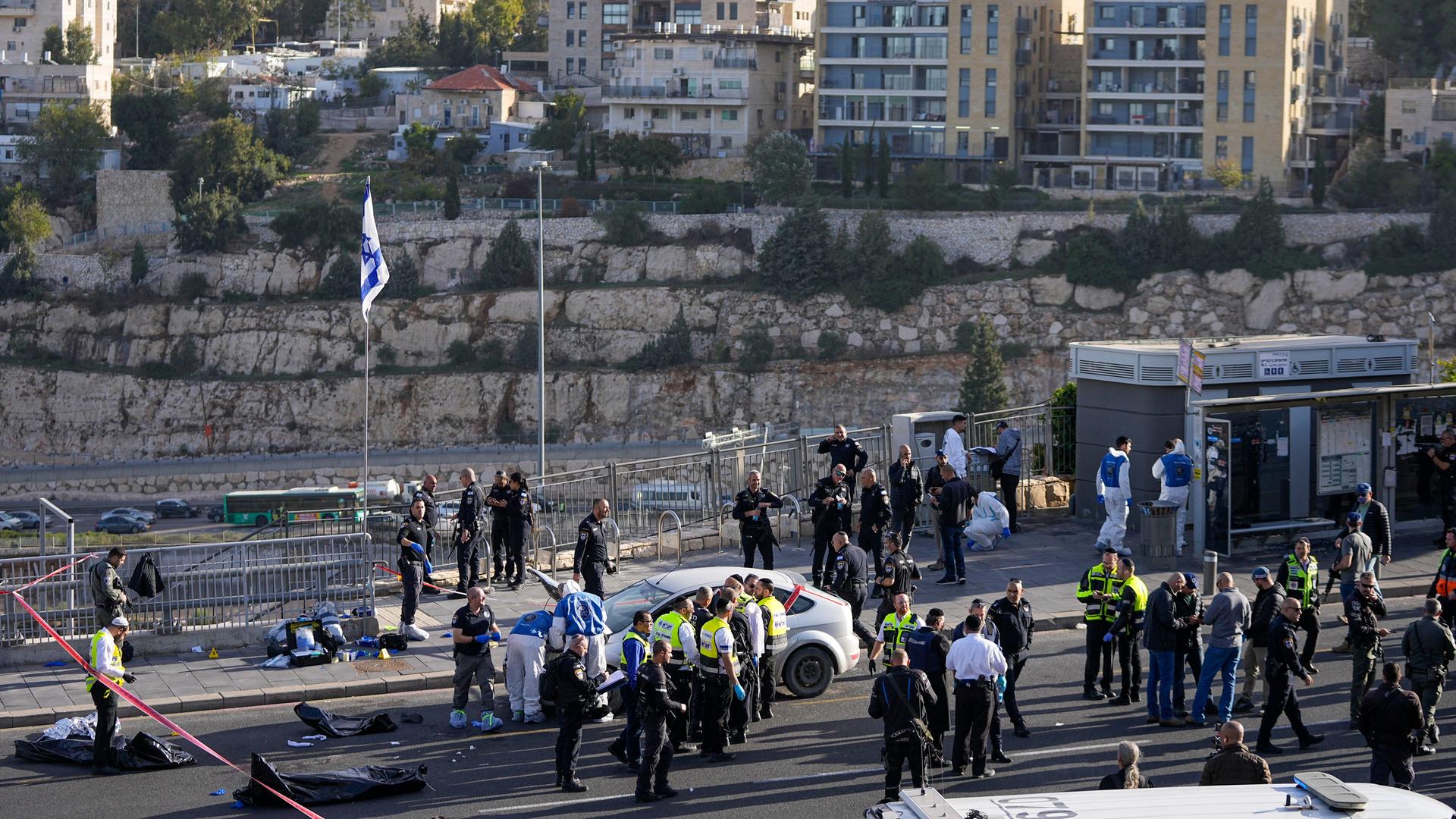 Israelische Polizisten stehen um die Bushaltestelle.