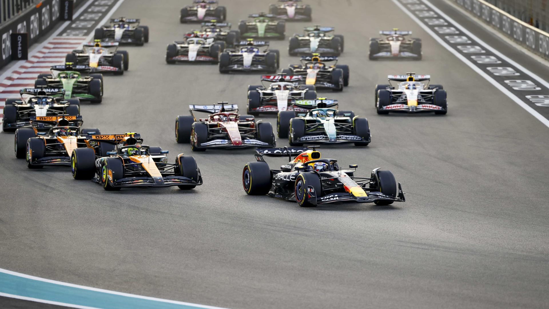 Eine Szene kurz nach dem Start des Formel-1-Rennens in Abu Dhabi, die Rennwagen fahren dicht hintereinander in eine Kurve.