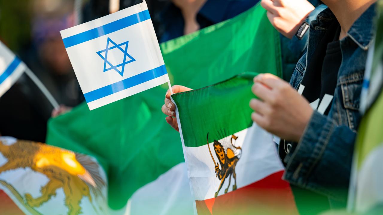 Eine Frau hält eine israelische und eine iranische Fahne während einer Kundgebung auf der Wiese gegenüber des iranischen Konsulats. Erstmals in der Geschichte der Islamischen Republik hatte der Iran seinen Erzfeind Israel in der Nacht direkt angegriffen.