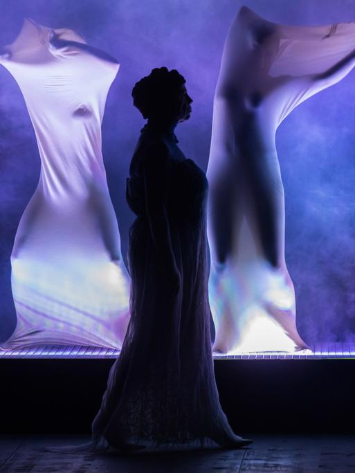 Aufführung des Stücks "Die Bibel" im Theater Rudolstadt. Ein in blau gehaltenes Bühnenbild mit Darstellern, die in weiße Tücher gehüllkt sind. 