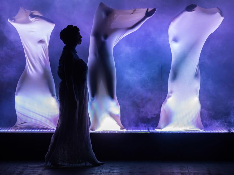 Aufführung des Stücks "Die Bibel" im Theater Rudolstadt. Ein in blau gehaltenes Bühnenbild mit Darstellern, die in weiße Tücher gehüllkt sind. 