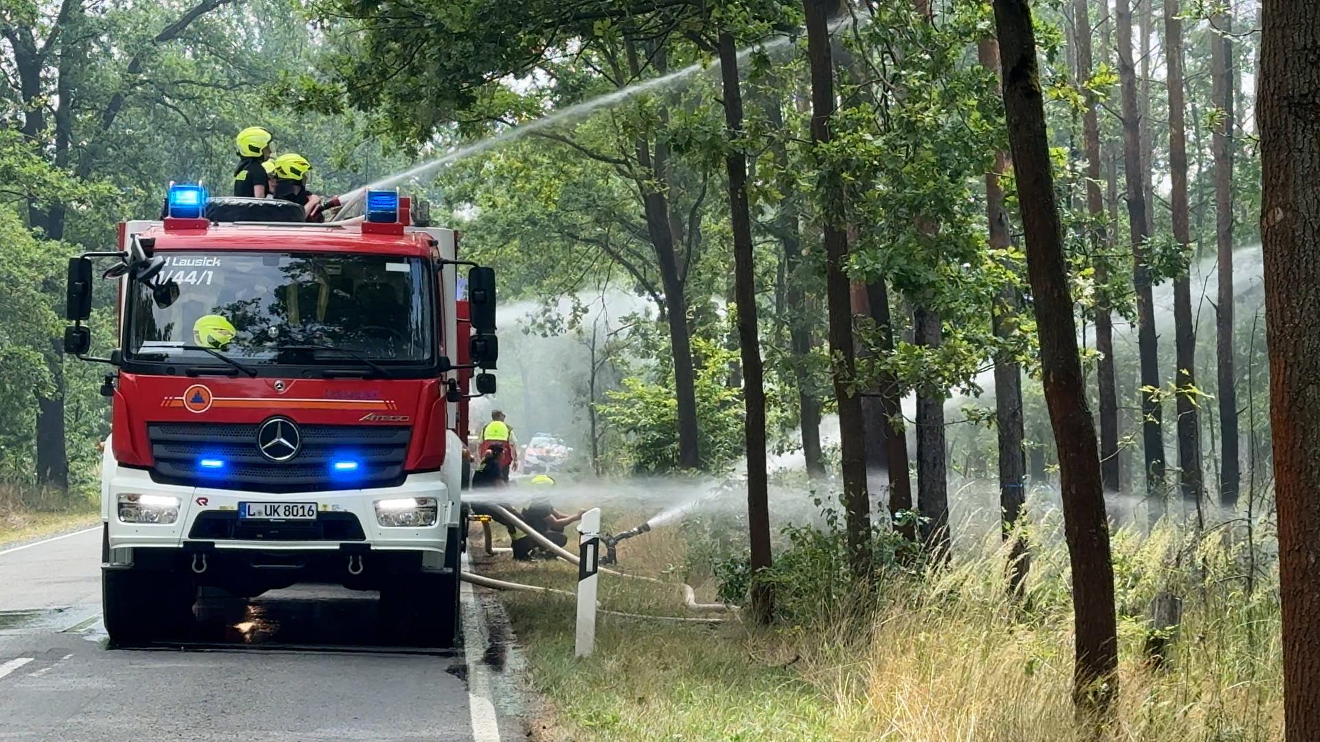 Das Foto zeigt ein Löschfahrzeug im Einsatz im Wald in der Gohrischheide.