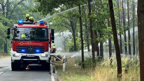 Das Foto zeigt ein Löschfahrzeug im Einsatz im Wald in der Gohrischheide.