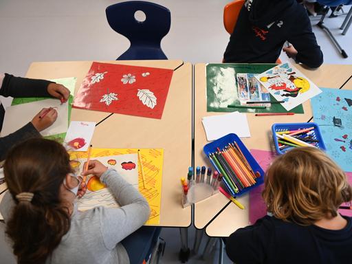 Kinder von hinten. Sie sitzen an einem Tisch und malen in einer Ganztagsschule in Berg am Laim. Kinder von hinten. Sie sitzen an einem Tisch und malen in einer Ganztagsschule in Berg am Laim.
